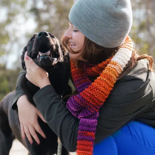 photo of woman hugging dog on winter day